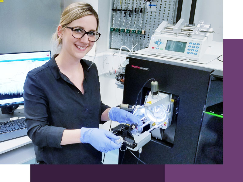 A photograph of Dr Corinne Lutomski using the Orbitrap Eclipse, mass spectrometer.